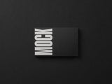 Black business card mockup on a black paper background top view.