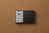 Black business card mockup on a cardboard background top view.