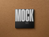 Square card mockup on a cardboard background top view.