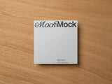 Square card mockup on a wooden background top view.